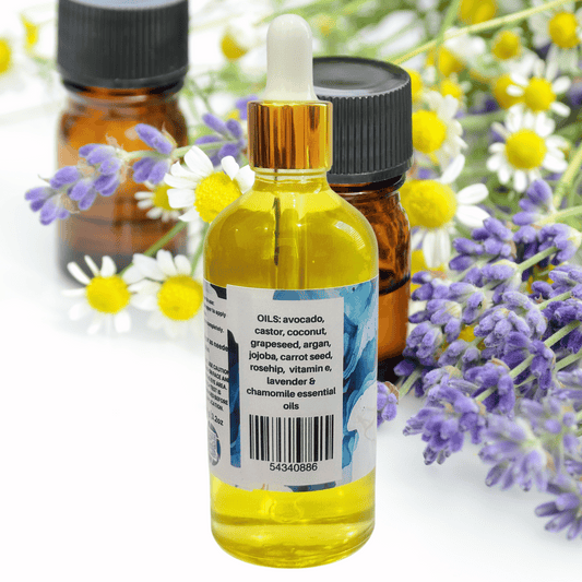 Bottle of essential oil with a dropper on a white background with flowers.