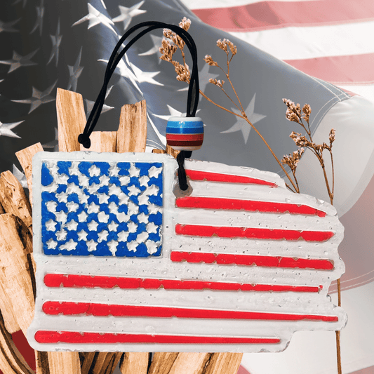 American flag car freshie with palo santo sticks against an American flag background