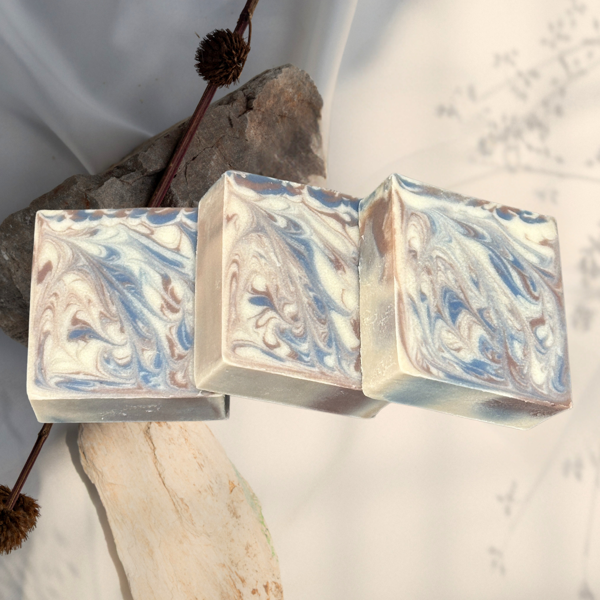 Three marbled soap bars on a neutral background