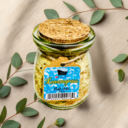 Jar of Lemongrass bath salts with a cork lid on a beige fabric background with eucalyptus leaves.