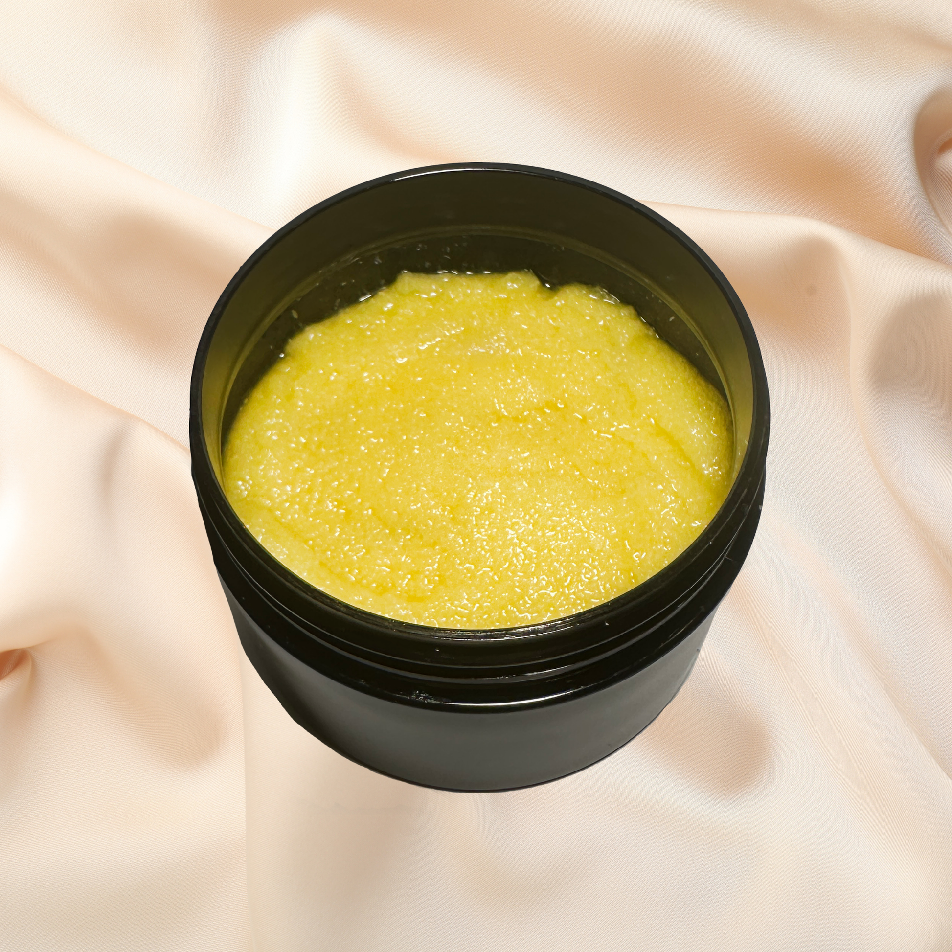 Black container with yellow scrub on a beige fabric background