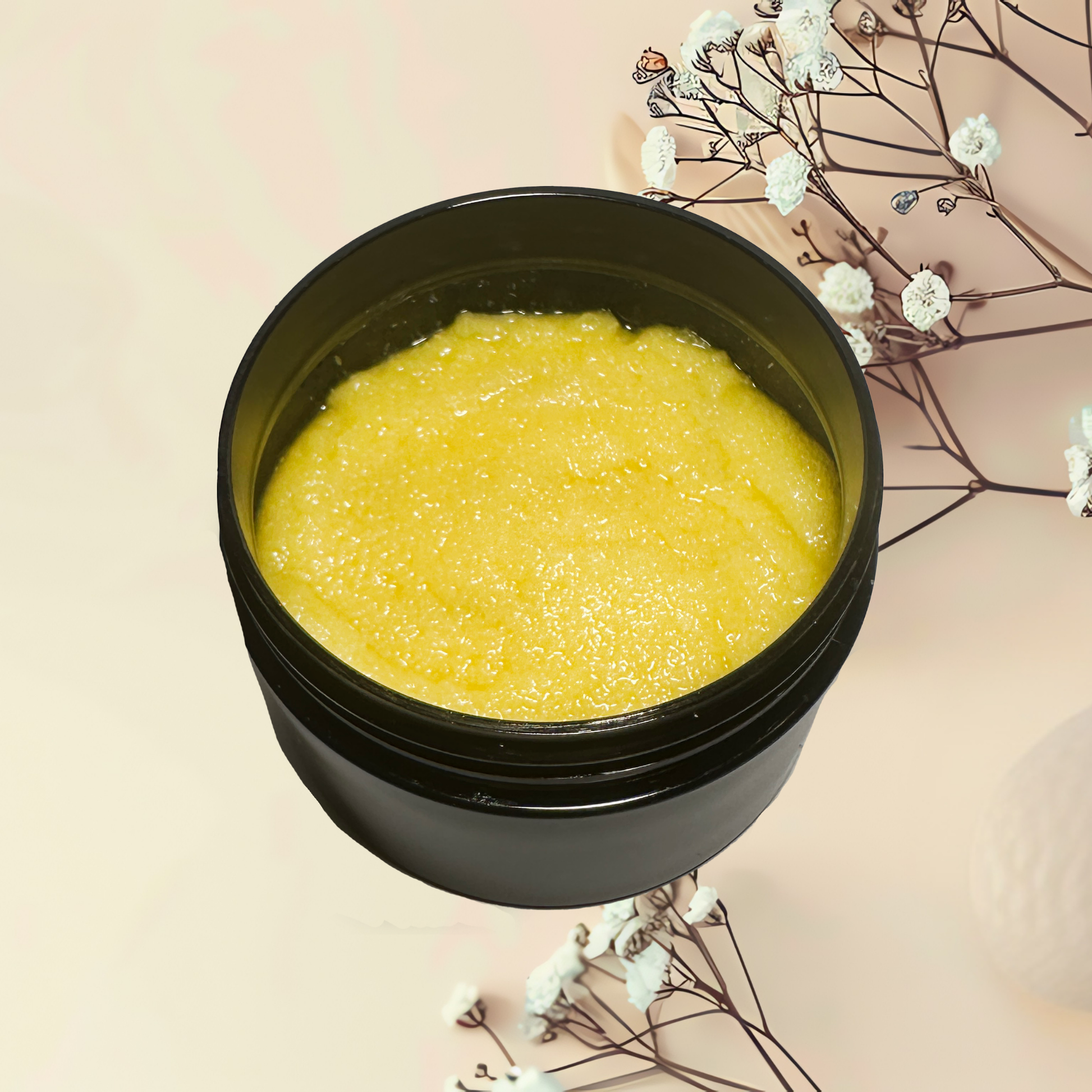 Black container with yellow scrub on a light pink background with white flowers.