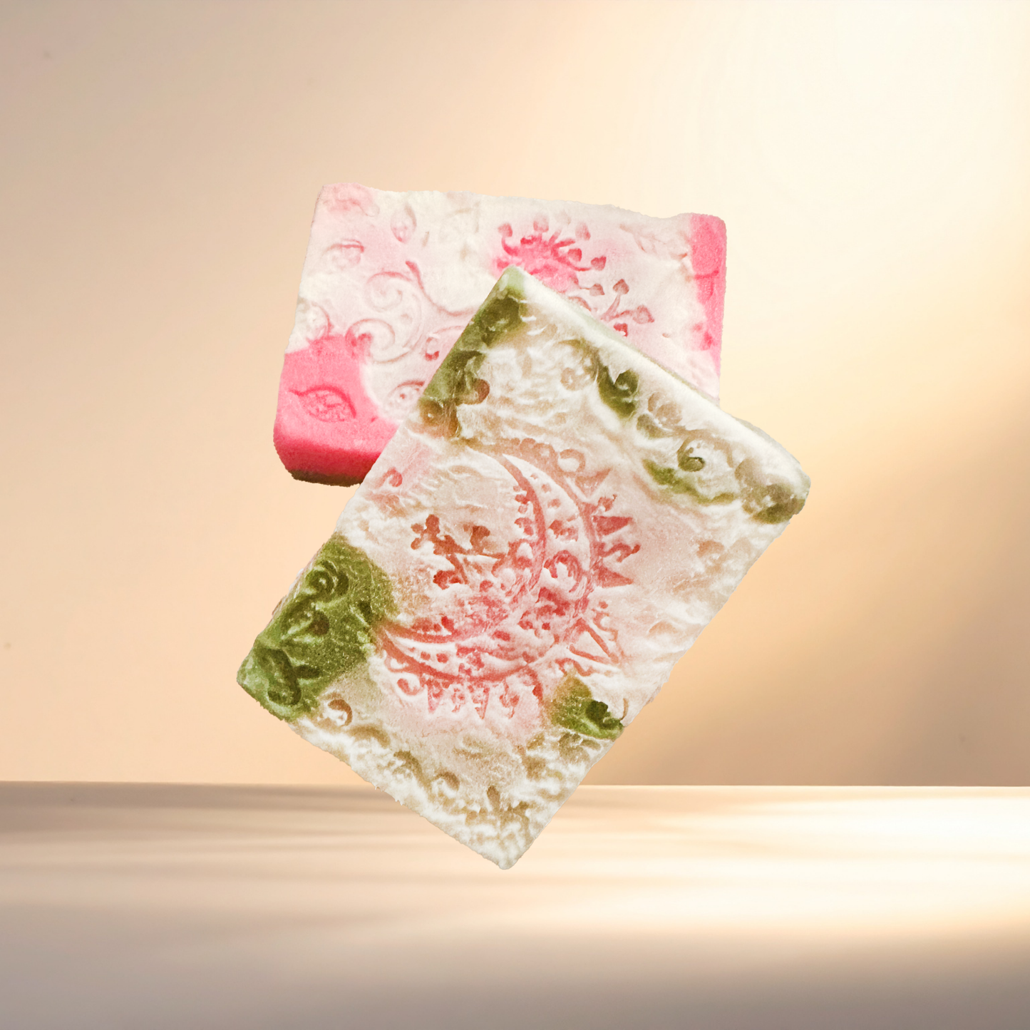 Two decorative soap bars with intricate designs on a gradient background