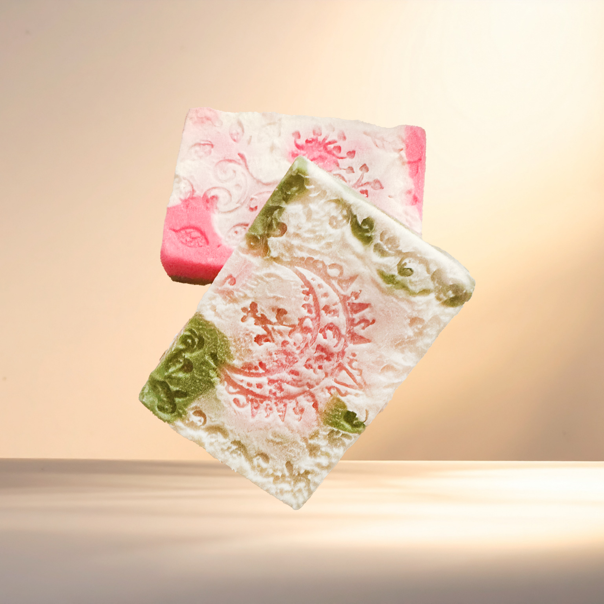 Two decorative soap bars with intricate designs on a gradient background