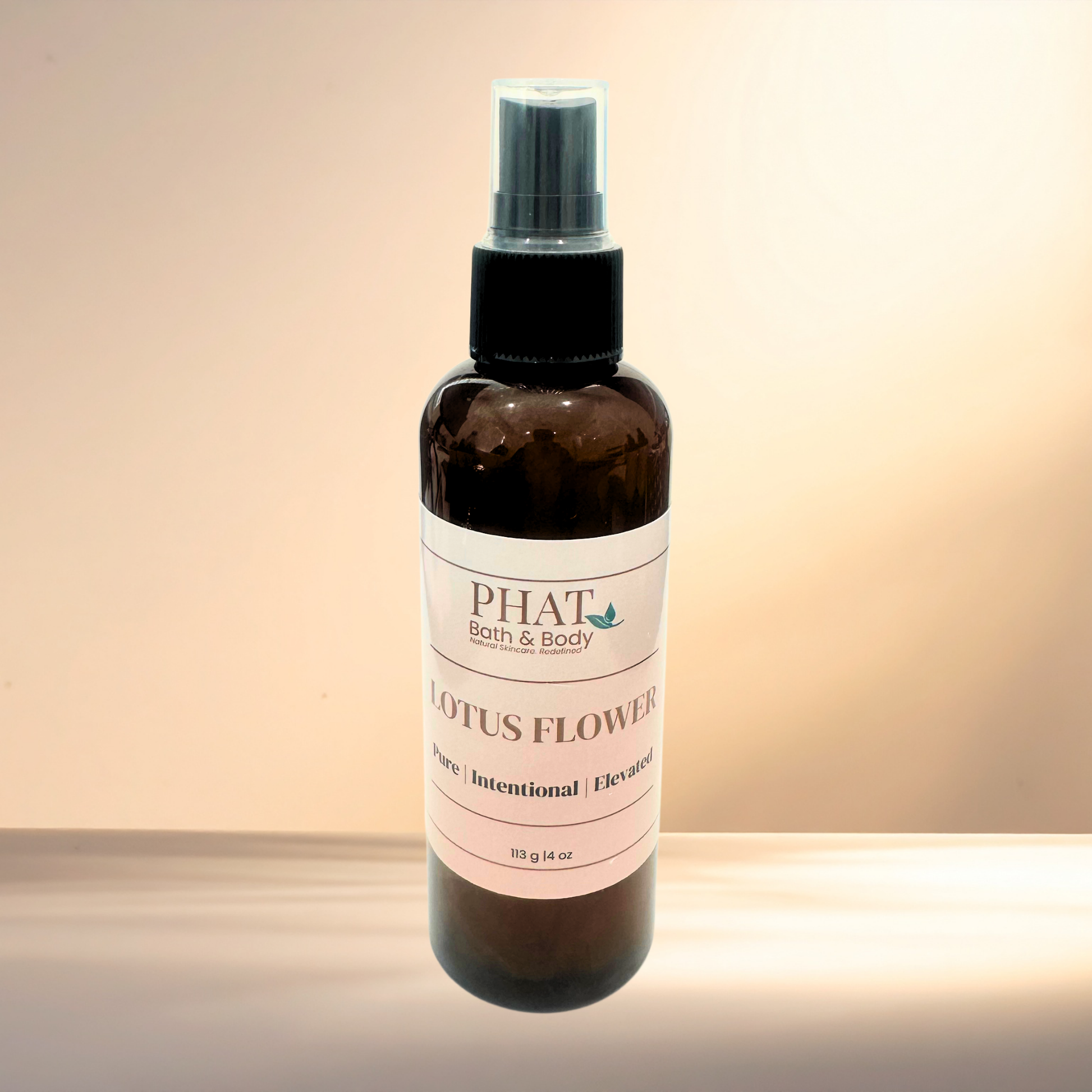Bottle of PHAT Bath & Body Lotus Flower spray on a gradient background