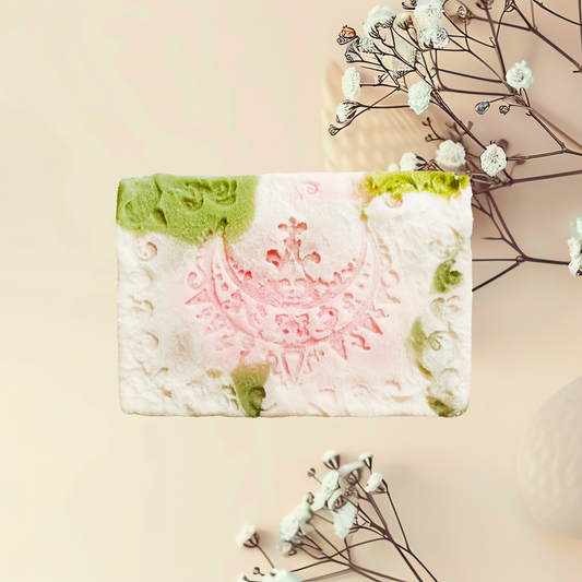 Handmade soap bar with floral design on a beige background