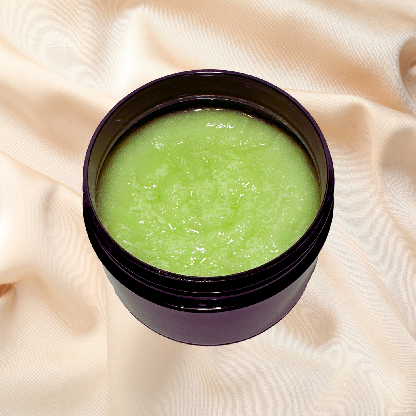 Jar of green scrub on a beige fabric background