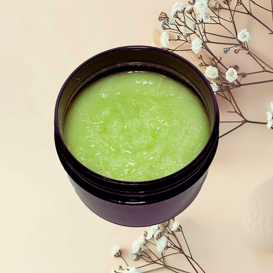 Green scrub in a purple jar with white flowers on a beige background