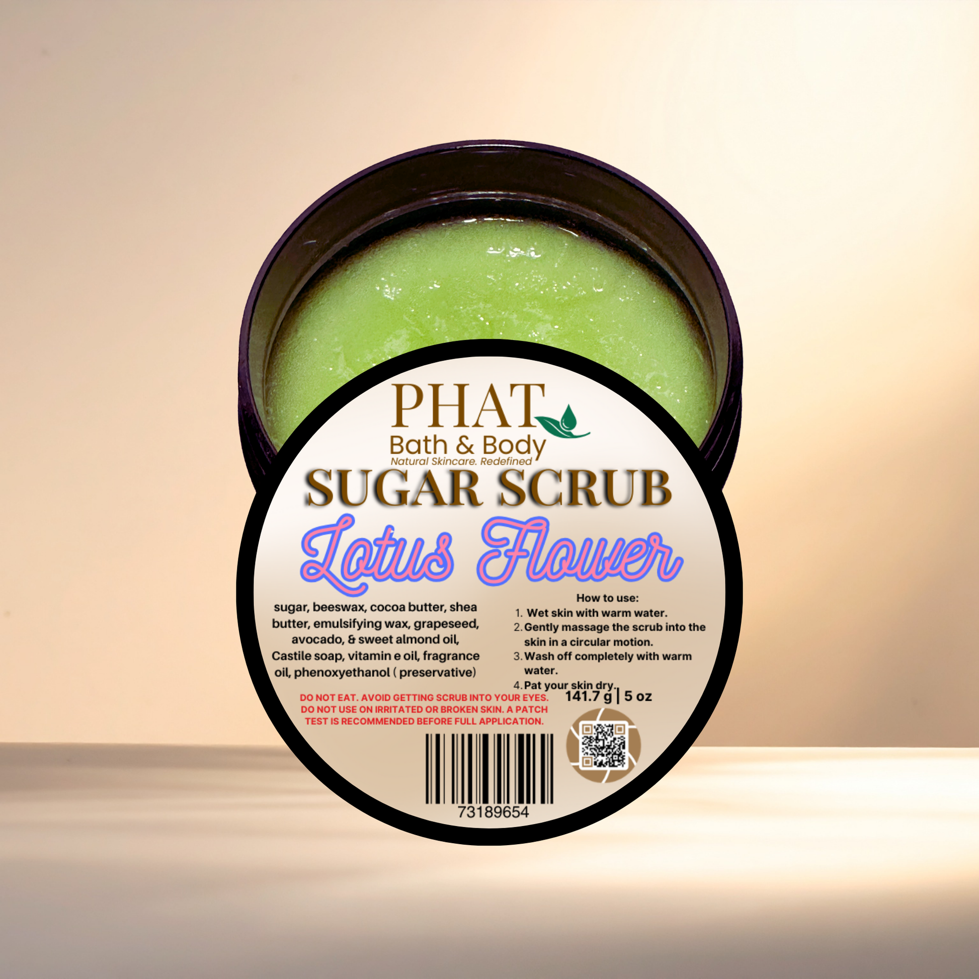 Green sugar scrub in a container with 'Phat Bath & Body' label on a beige background