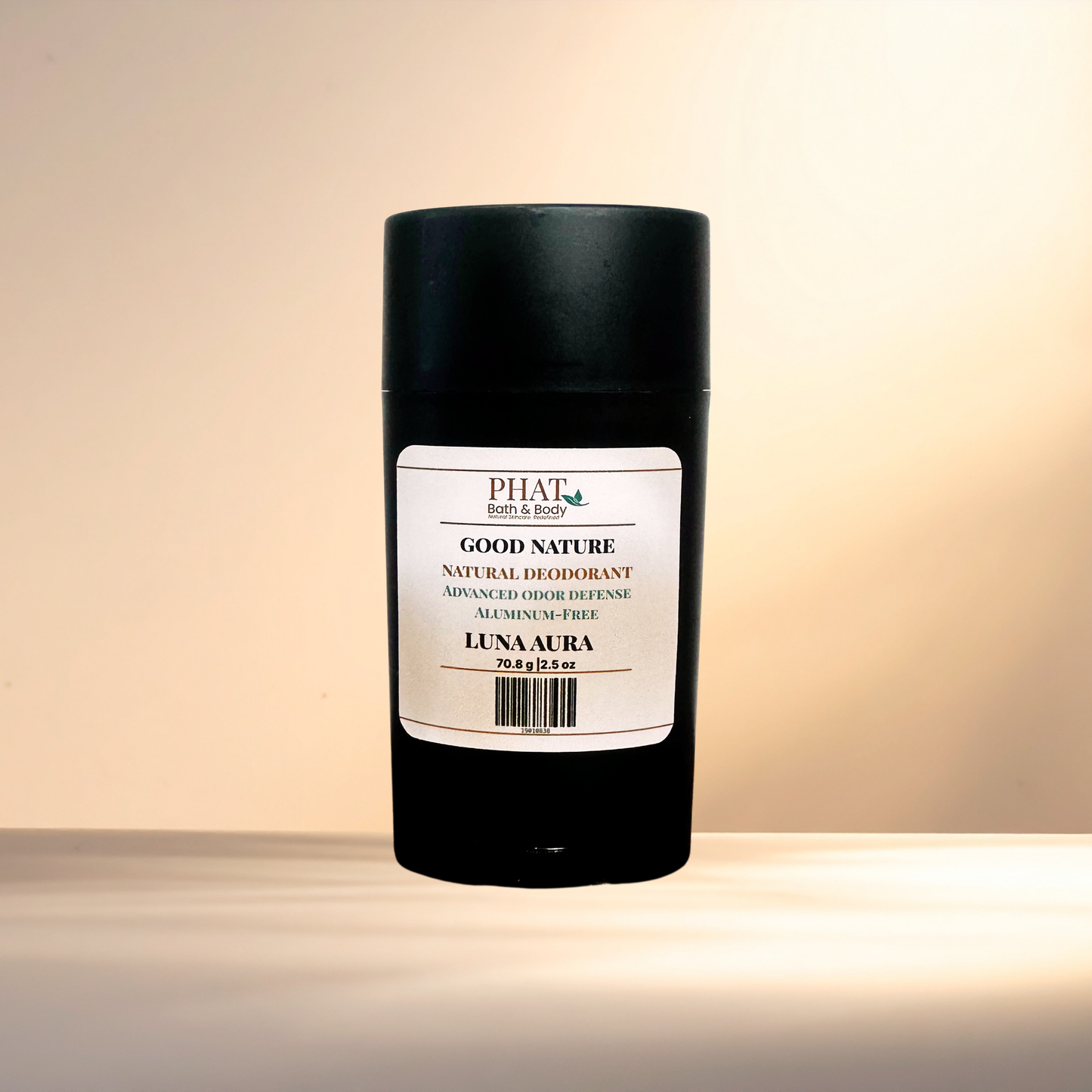 A black cylindrical deodorant stick with a white label reading Good Nature Natural Deodorant, Luna Aura, set against a warm beige gradient background.