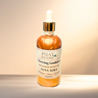 Bottle of PHAT Bath & Body Glowing Goddess Shimmer Body Oil on a gradient background