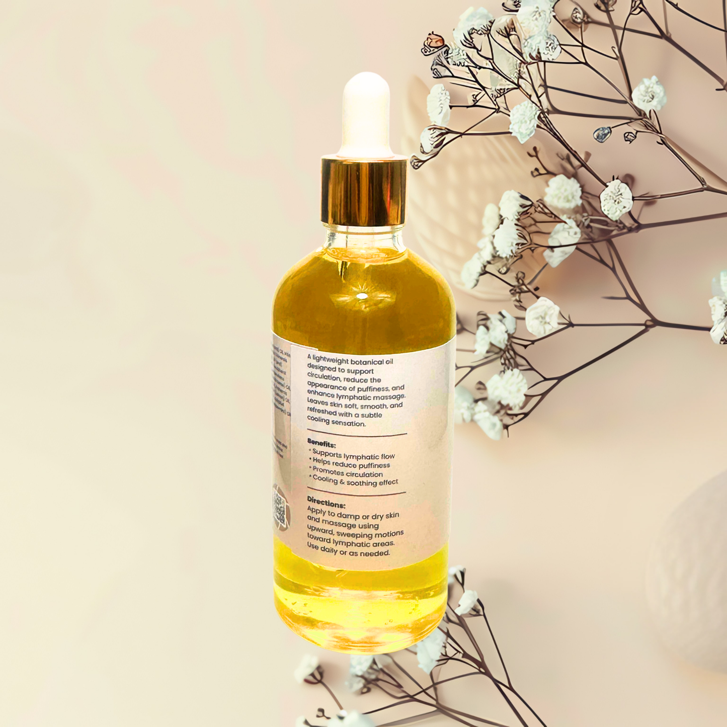 Bottle of yellow liquid with dropper on a beige background with white flowers