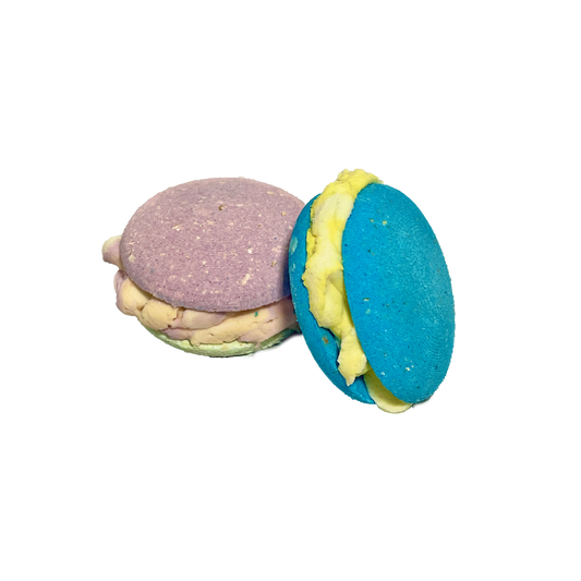 Two colorful macaron bubble bombs with different colored fillings on a white background