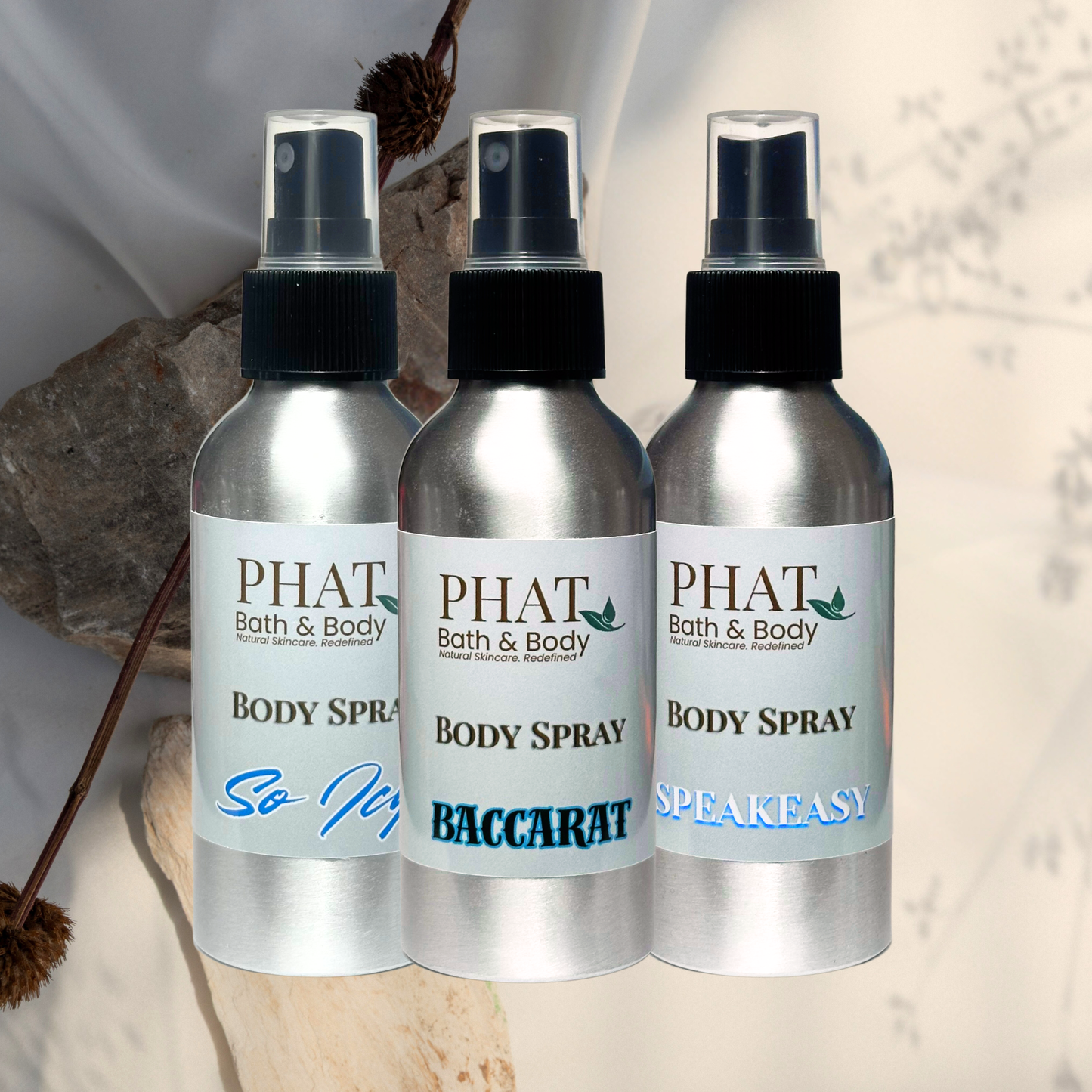 Three PHAT Bath & Body body spray bottles with different names on a neutral background