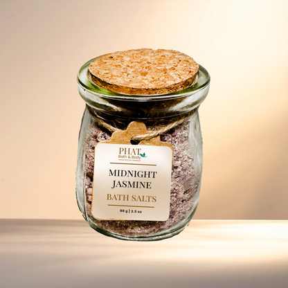 Jar of 'Midnight Jasmine' bath salts with a cork lid on a gradient background