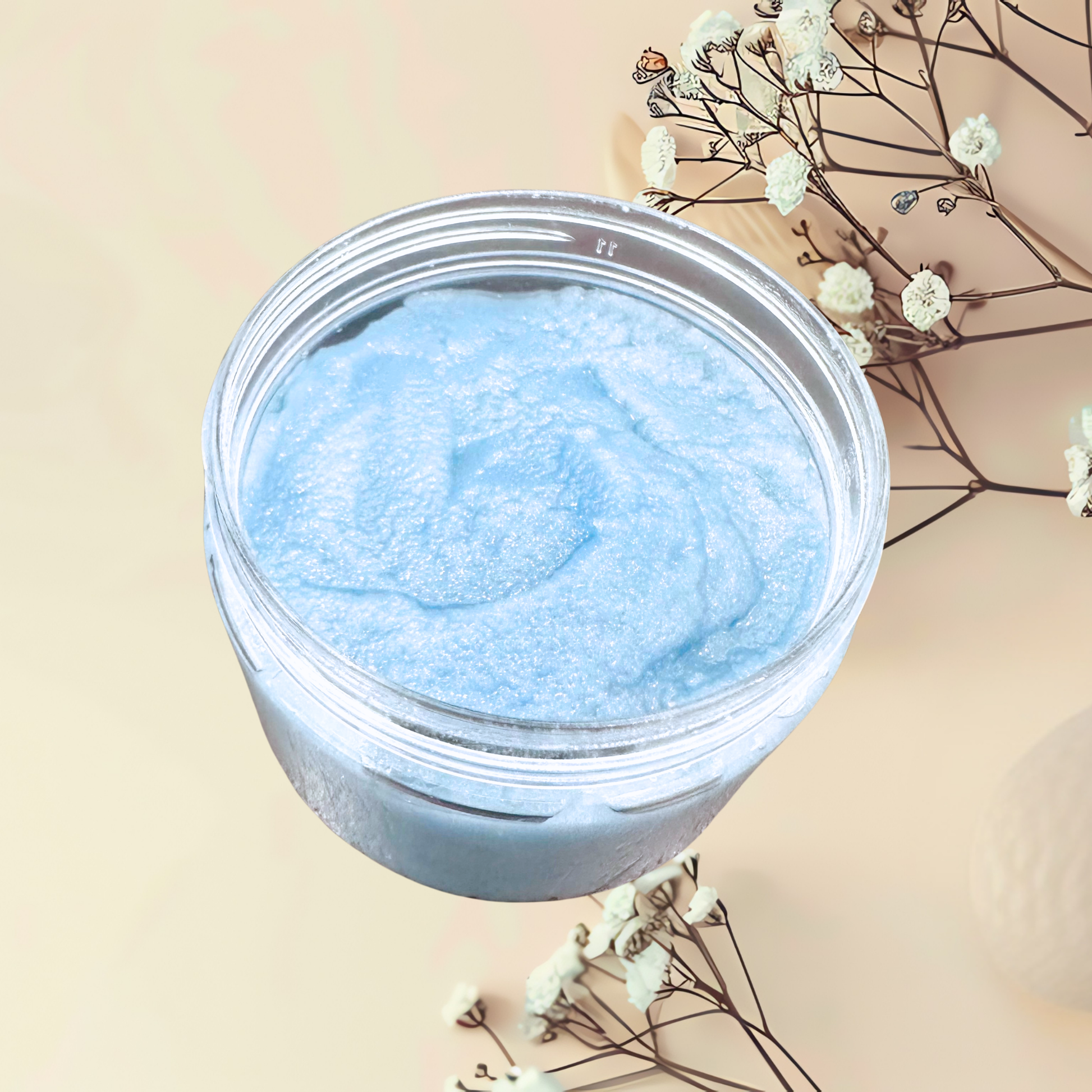 Jar of blue scrub with a beige background and white flowers