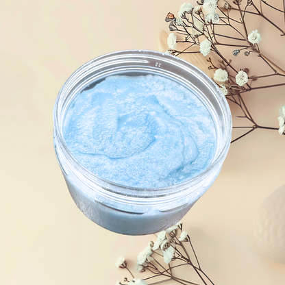 Jar of blue scrub with a beige background and white flowers