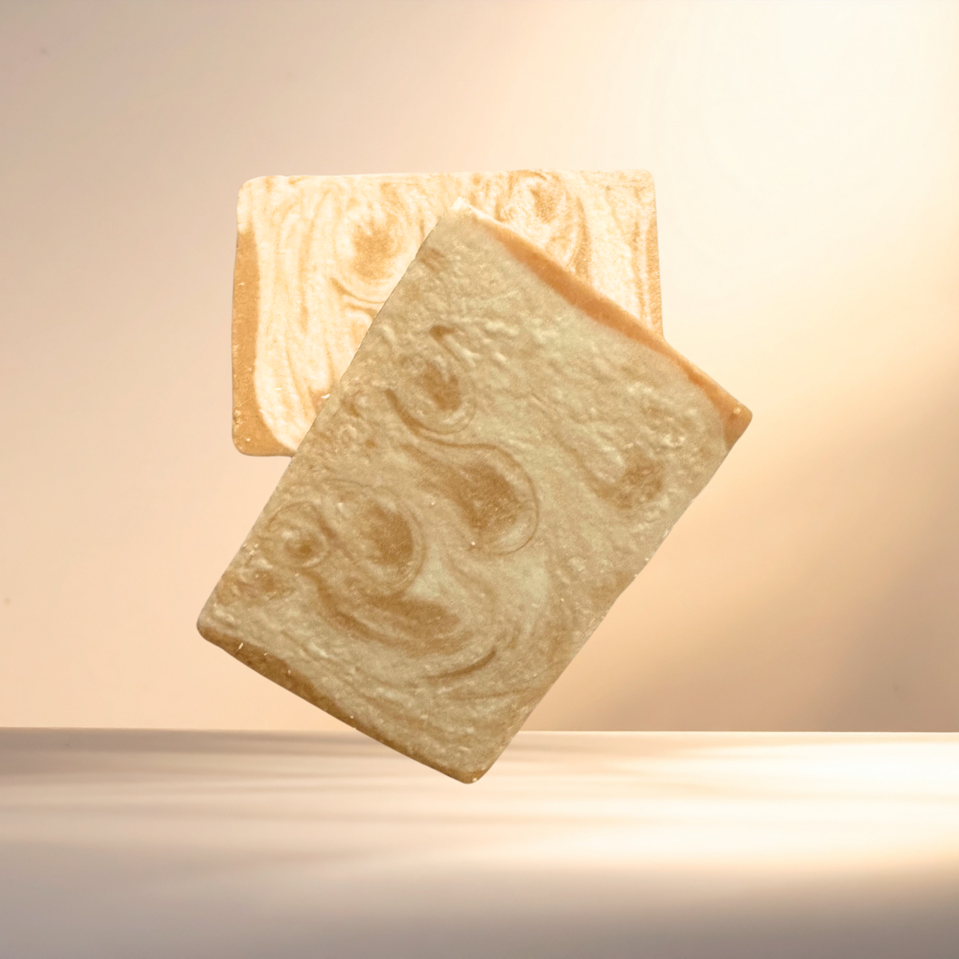 Two bars of soap with a marbled pattern on a neutral background