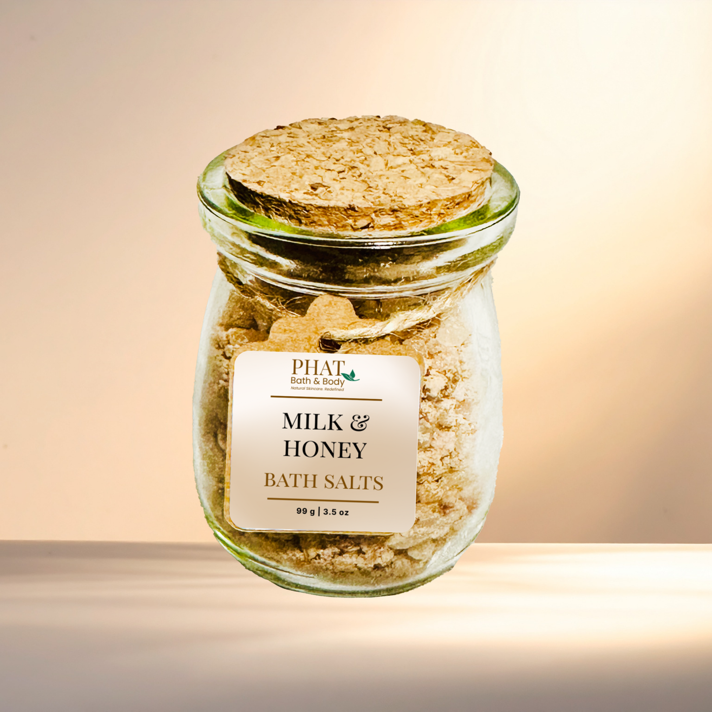 Jar of milk and honey bath salts with a cork lid on a gradient background
