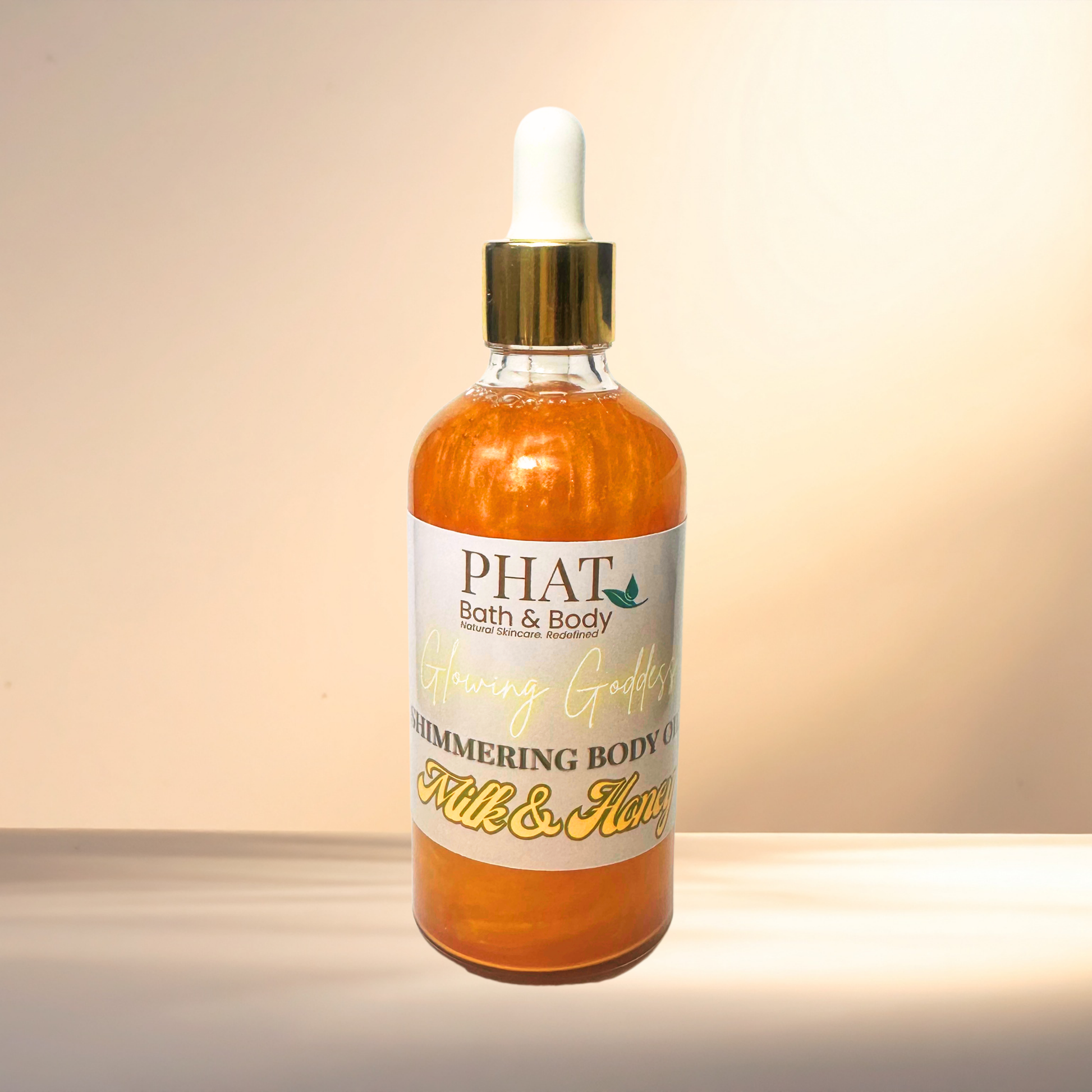 Bottle of PHAT Bath & Body shimmering body oil on a gradient background