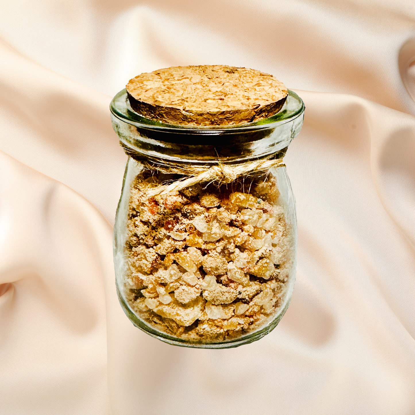 Glass jar with cork lid containing bath salts on a soft beige fabric background