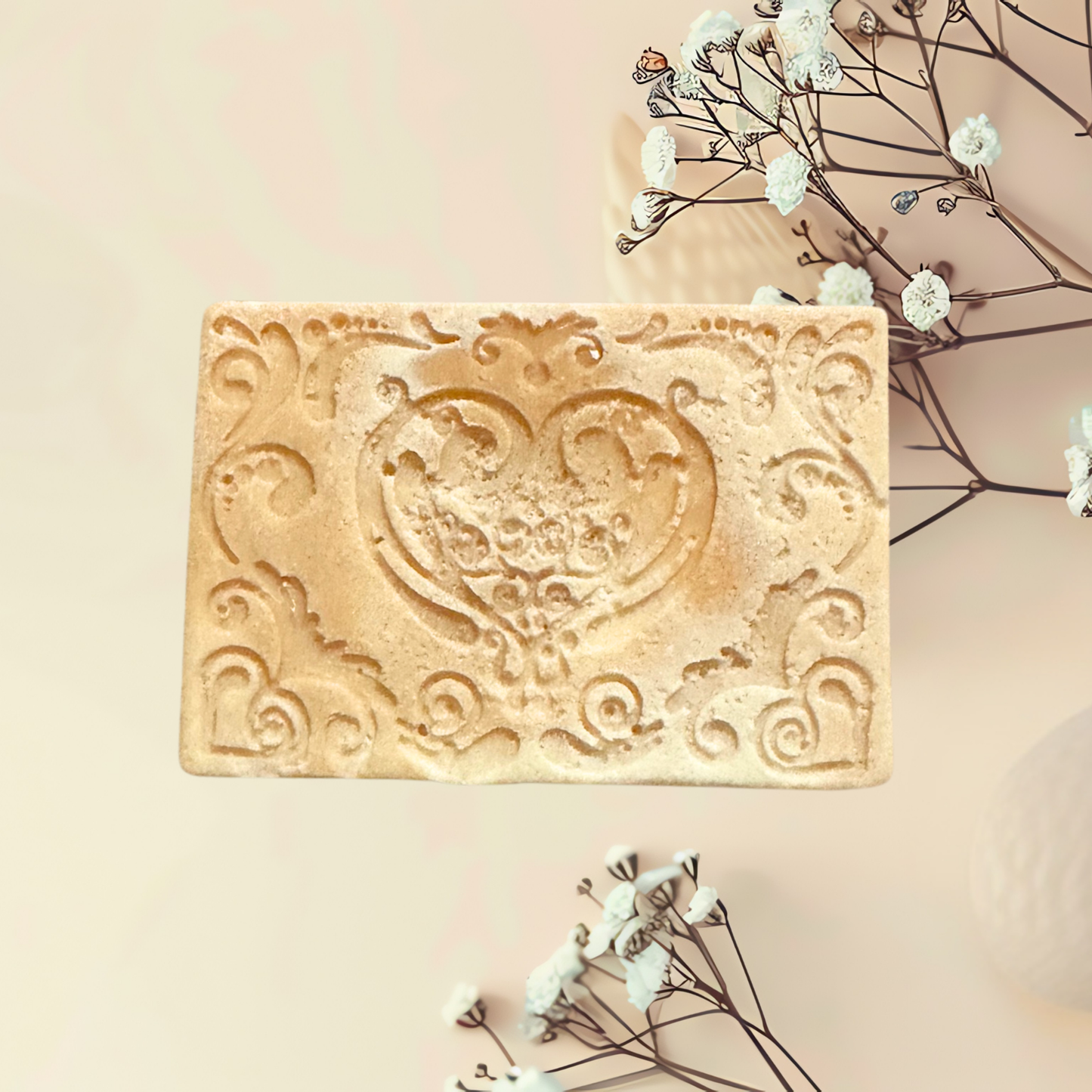 Decorative soap bar with intricate design on a light background with flowers.