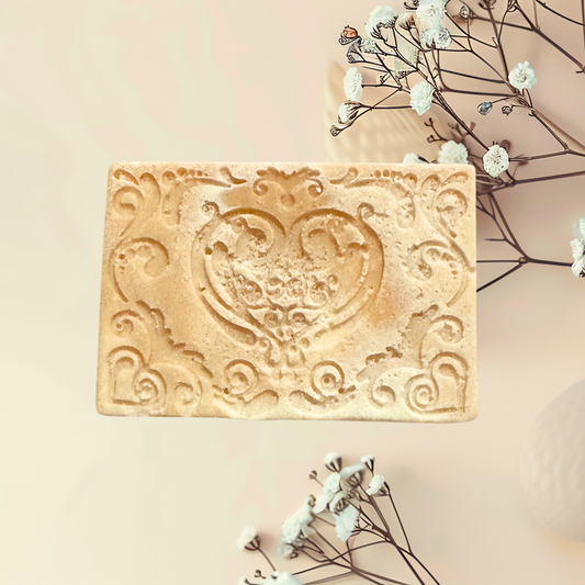 Decorative soap bar with intricate design on a light background with flowers.