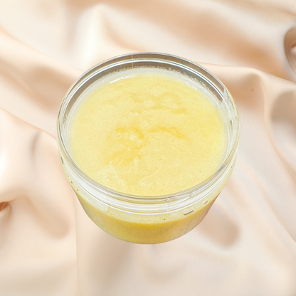 Jar of yellow scrub on a soft pink fabric background