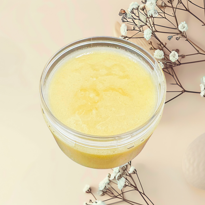 Jar of yellow scrub with white flowers on a beige background