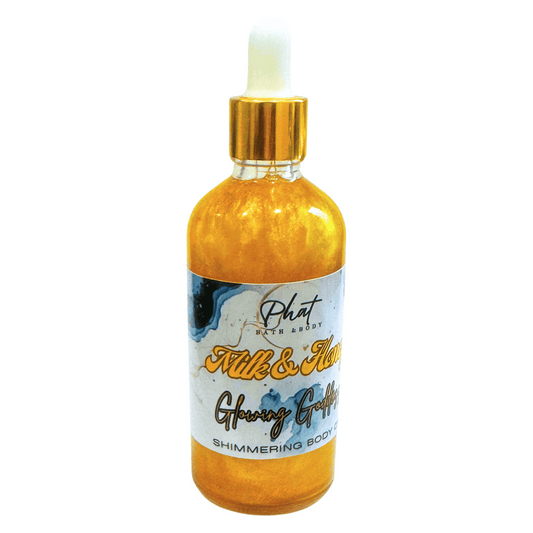 Shimmering body oil bottle with gold cap on a white background
