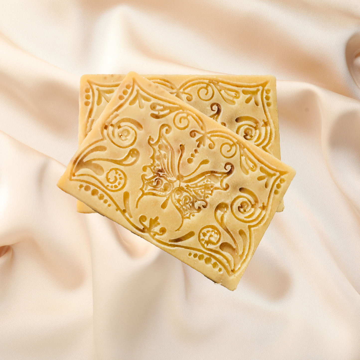 Decorative soap bar with intricate patterns on a soft fabric background
