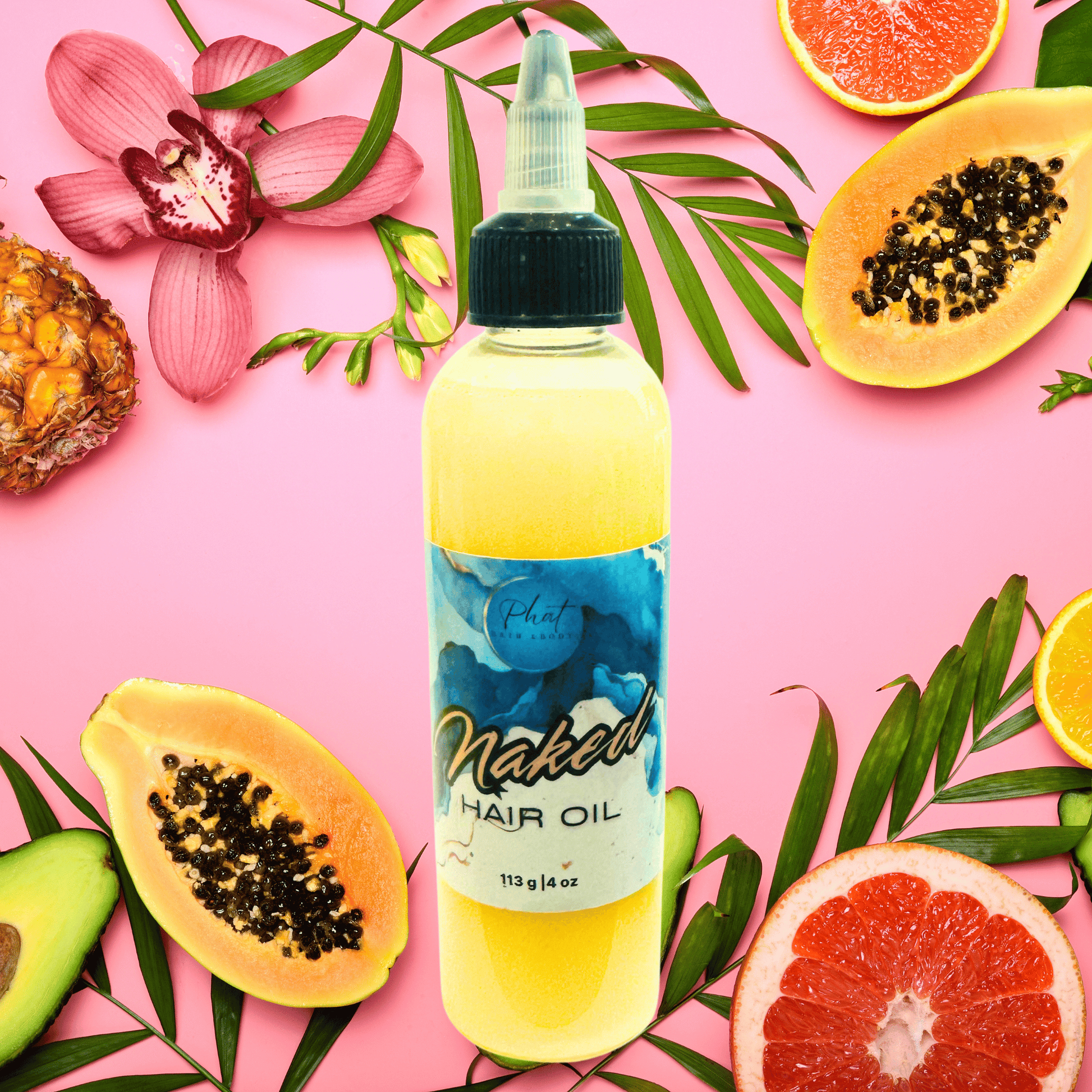 Bottle of hair oil next on a pink tropical fruit background