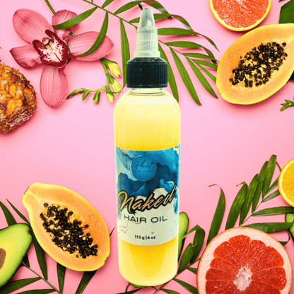 Bottle of hair oil next on a pink tropical fruit background