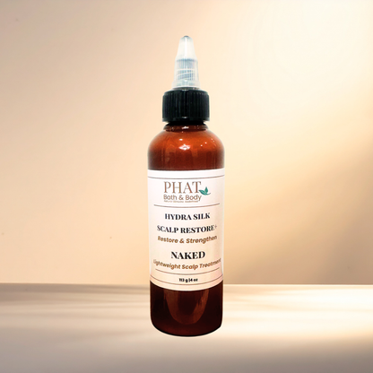 A amber bottle of PHAT Bath & Body Hydra silk Scalp Restore+ treatment with a black twist cap, set against a warm beige background.