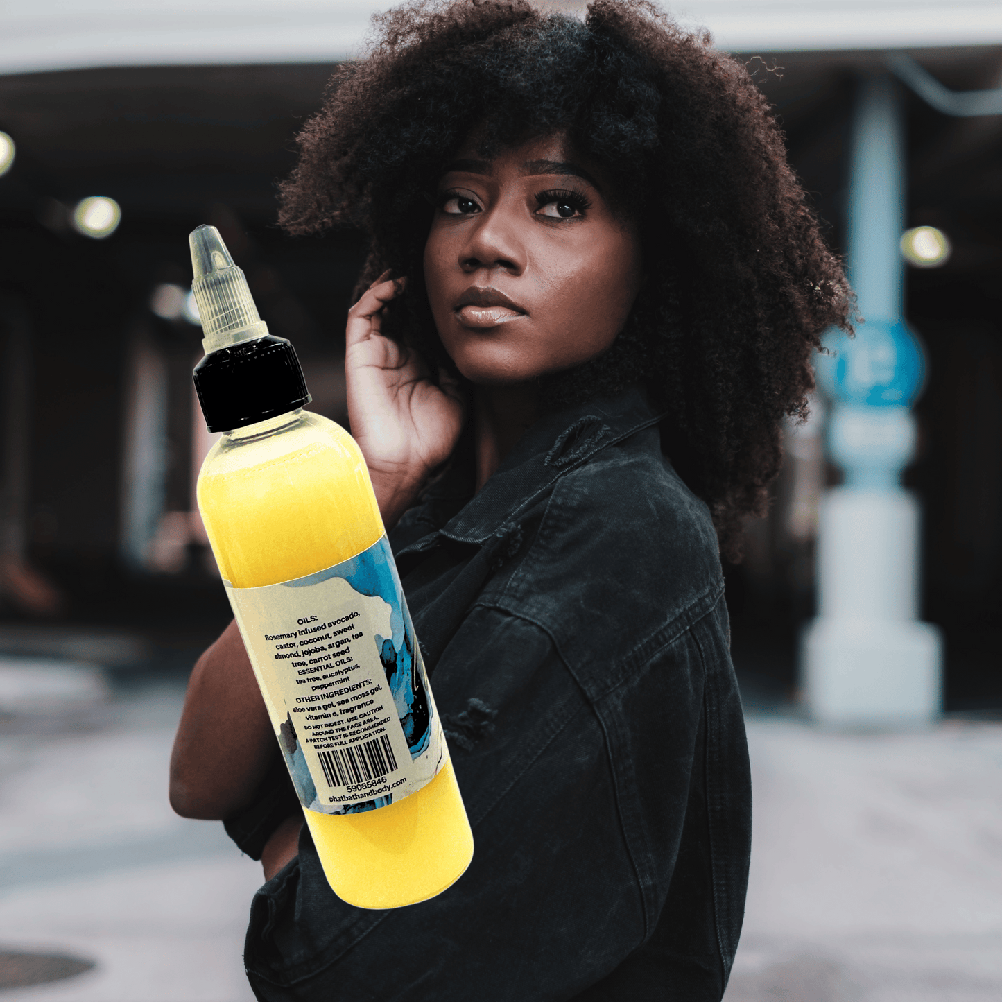 Woman holding a hair growth oil bottle with a ingredients label outdoors