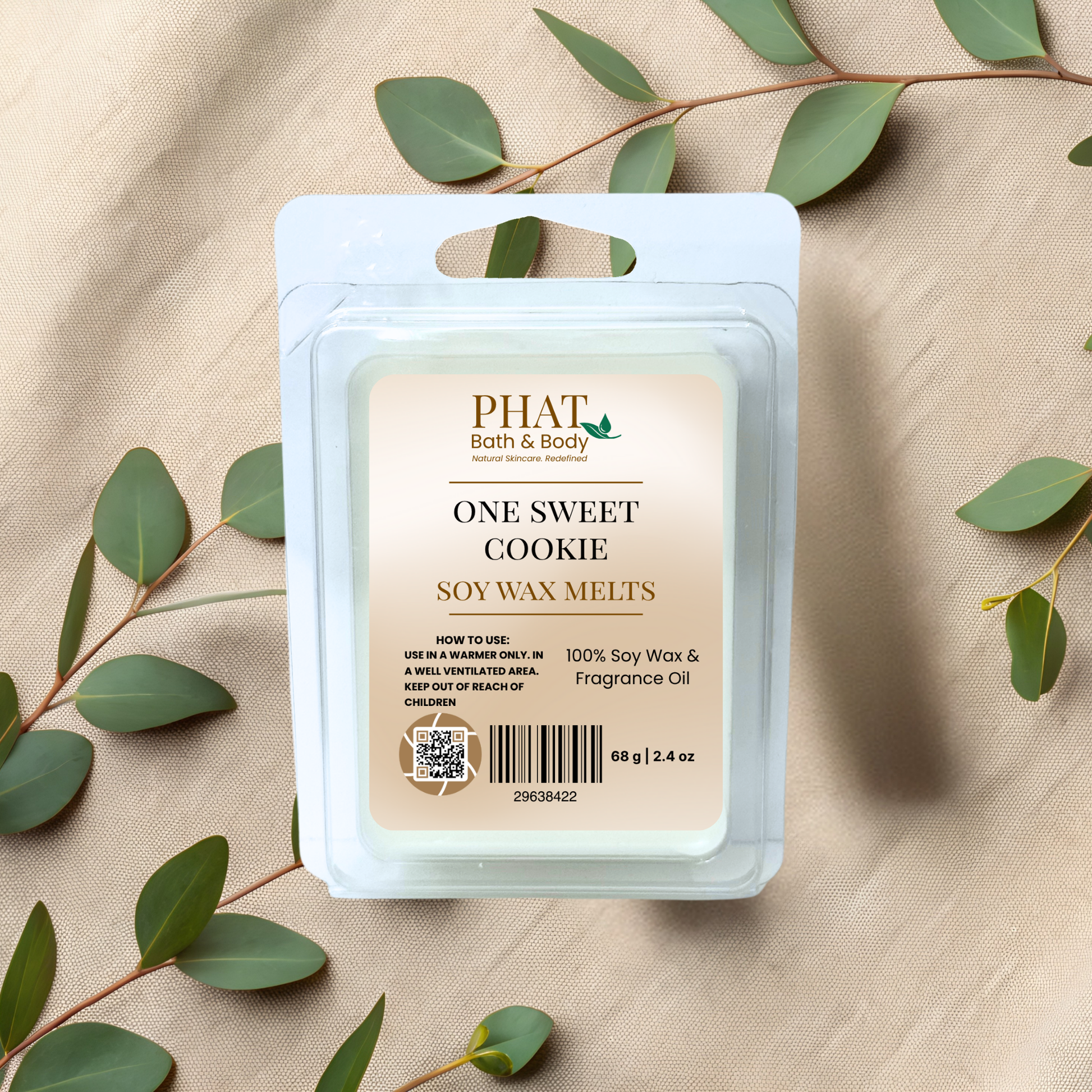 PHAT Bath & Body One Sweet Cookie soy wax melts packaging on a beige fabric background with green leaves.