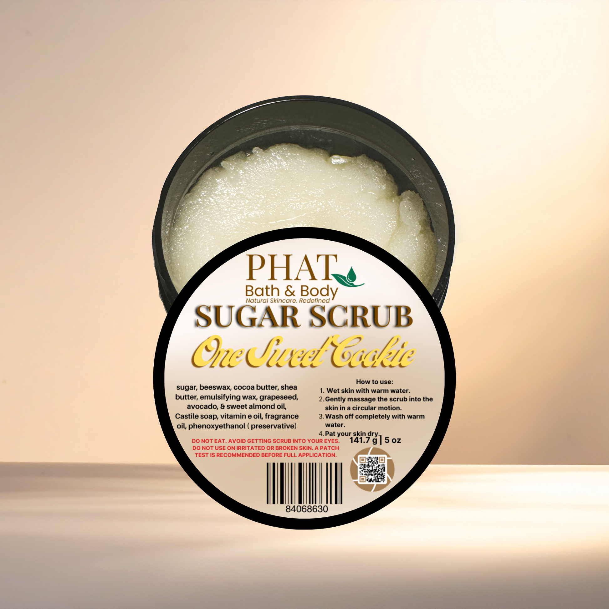 Jar of sugar scrub labeled 'One Sweet Cookie' from Phat Bath & Body on a beige background