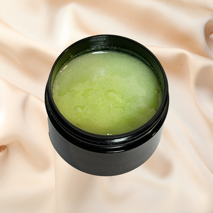Black jar with green scrub on a beige fabric background