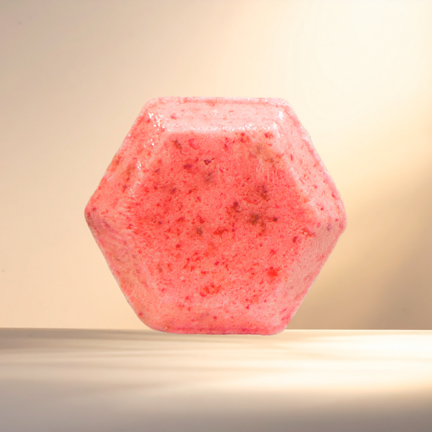 Hexagonal pink shower bomb on a beige background