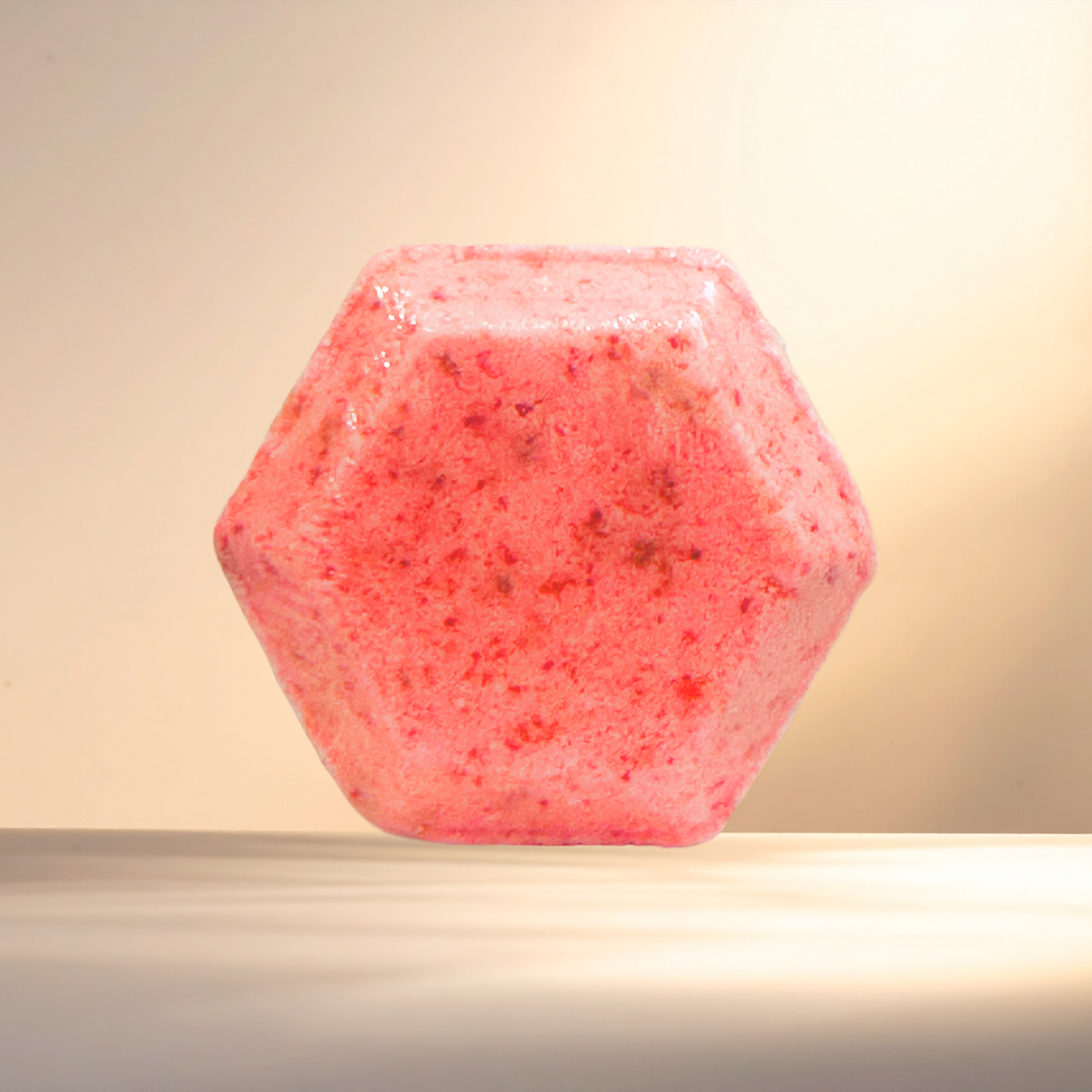Hexagonal pink shower bomb on a beige background