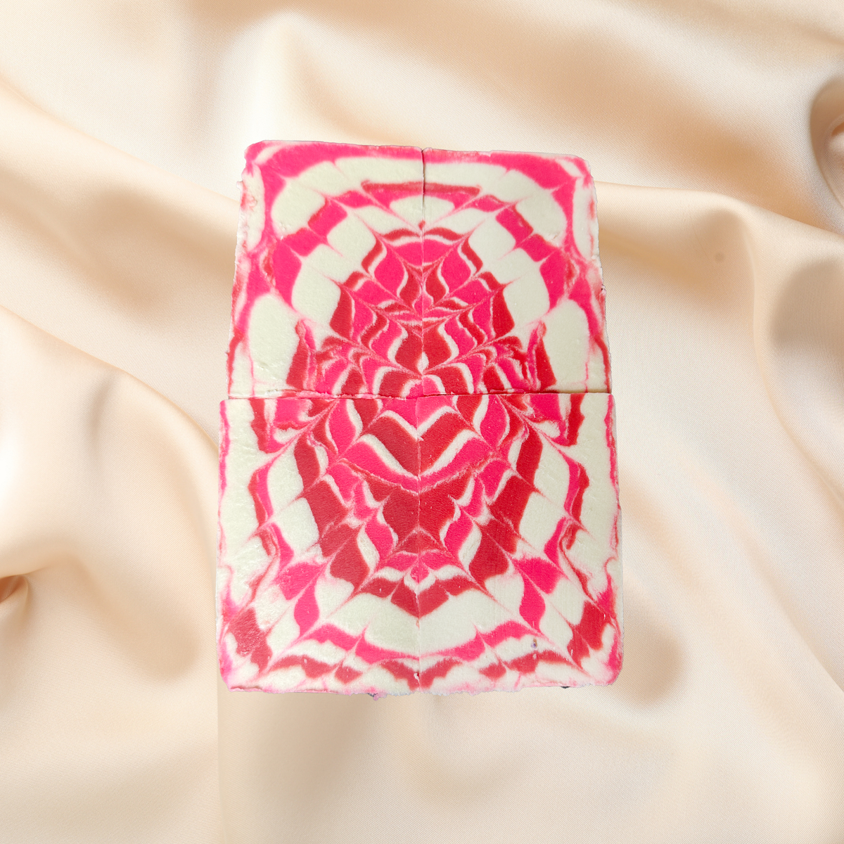 Pink and white patterned soap on a beige fabric background
