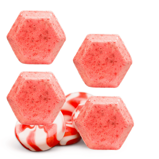 Hexagonal pink shower steamers with peppermint candy on a white background