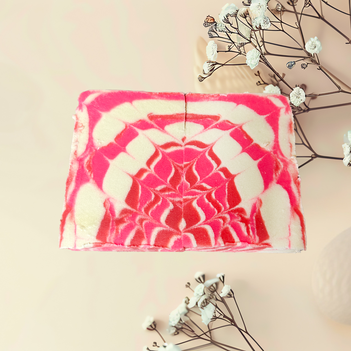 Pink and white patterned soap bar with decorative branches on a light background