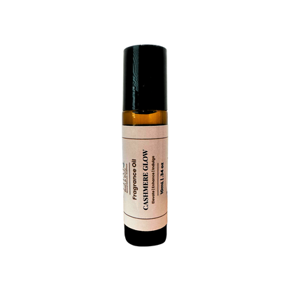An amber glass rollerball bottle of Cashmere Glow Fragrance Oil with a cream label and black cap, centered on a plain white background.