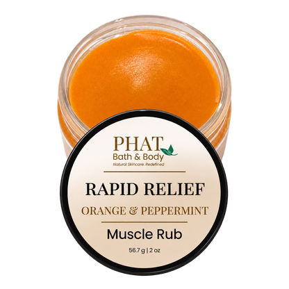 Phat Bath & Body Rapid Relief Muscle Rub in Orange & Peppermint, featuring an open 2 oz jar of smooth orange botanical massage balm with its branded lid. Formulated with coconut oil, beeswax, and warming botanicals for massaging tired areas.