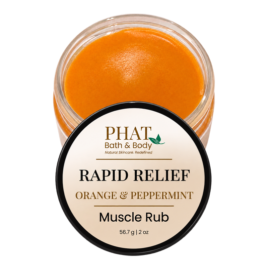 Phat Bath & Body Rapid Relief Muscle Rub in Orange & Peppermint, featuring an open 2 oz jar of smooth orange botanical massage balm with its branded lid. Formulated with coconut oil, beeswax, and warming botanicals for massaging tired areas.