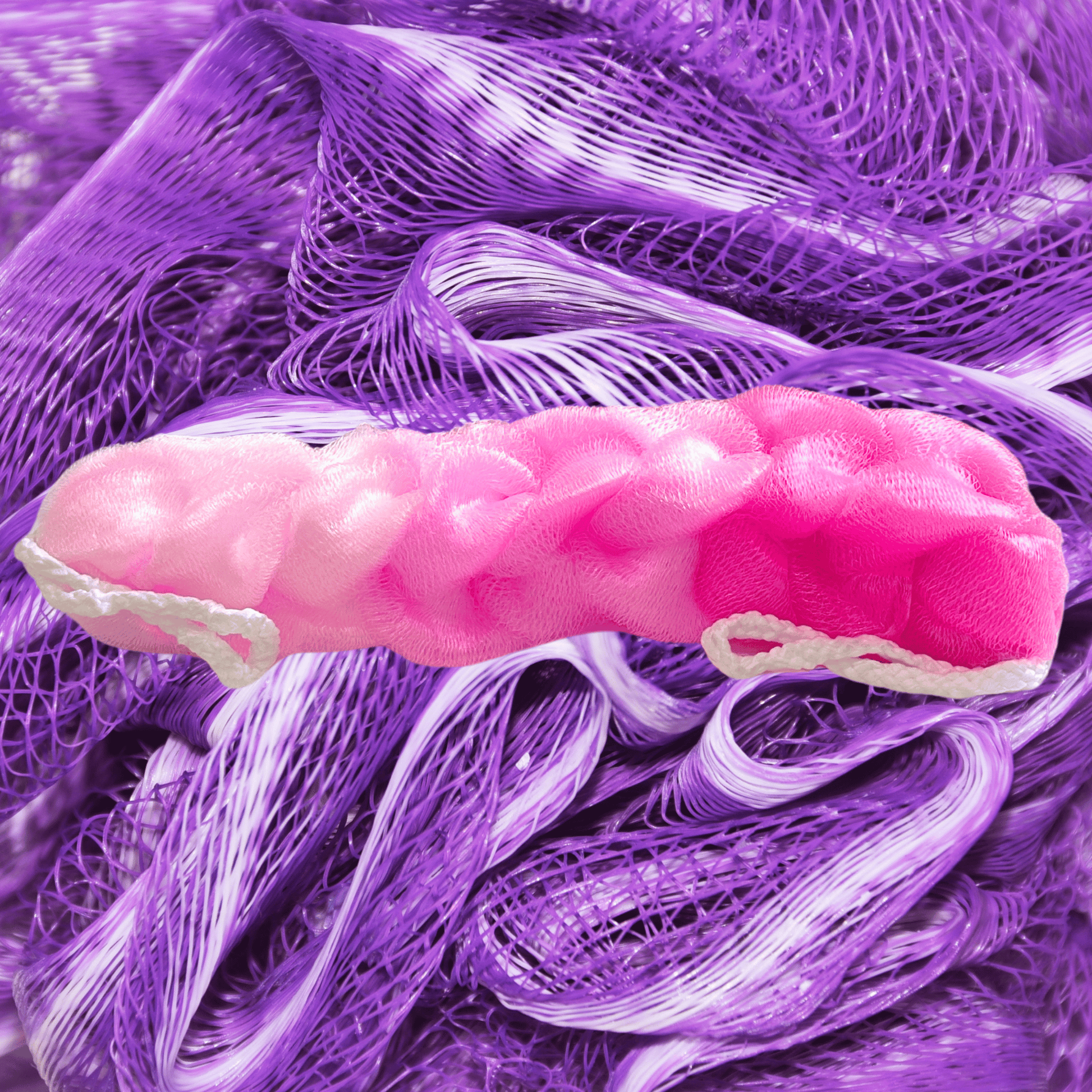 Pink mesh back scrubber on a purple loofah background