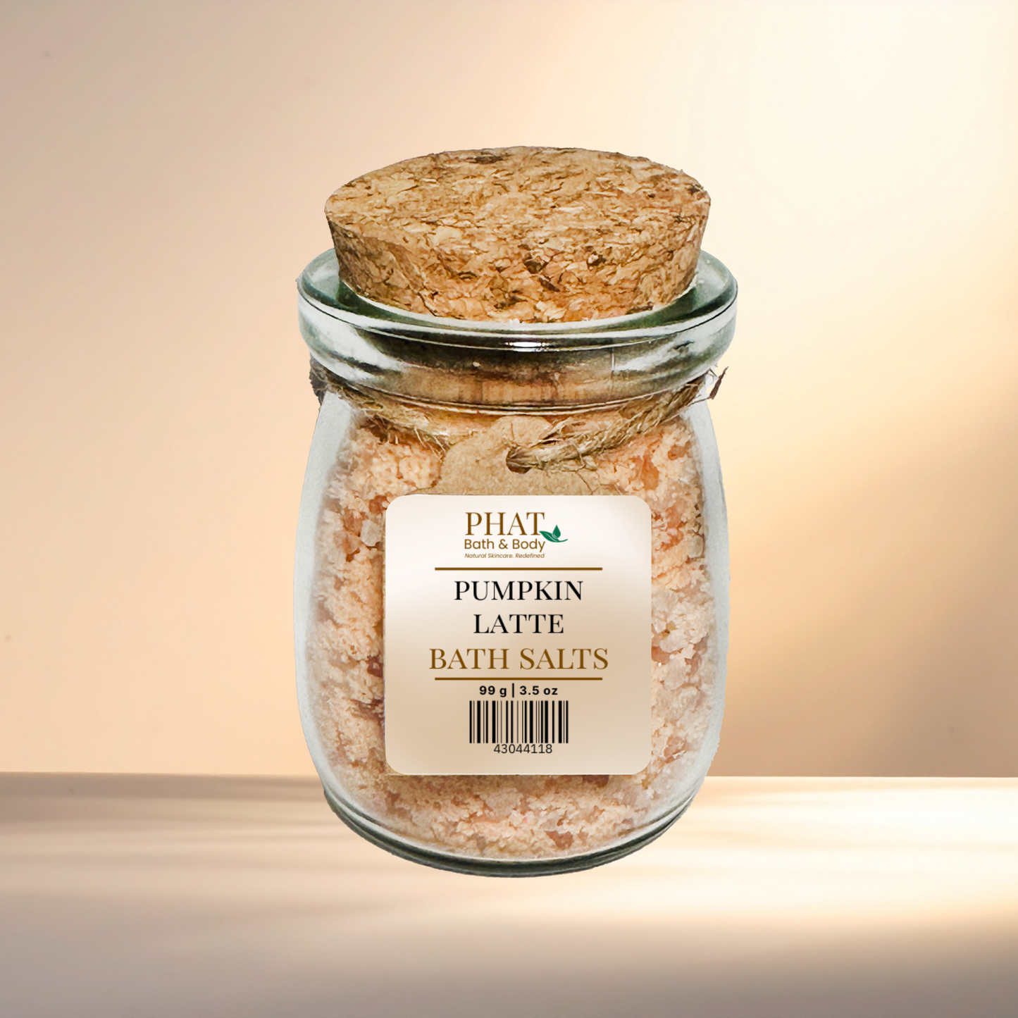 Glass jar of pumpkin latte bath salts with cork lid on a gradient background