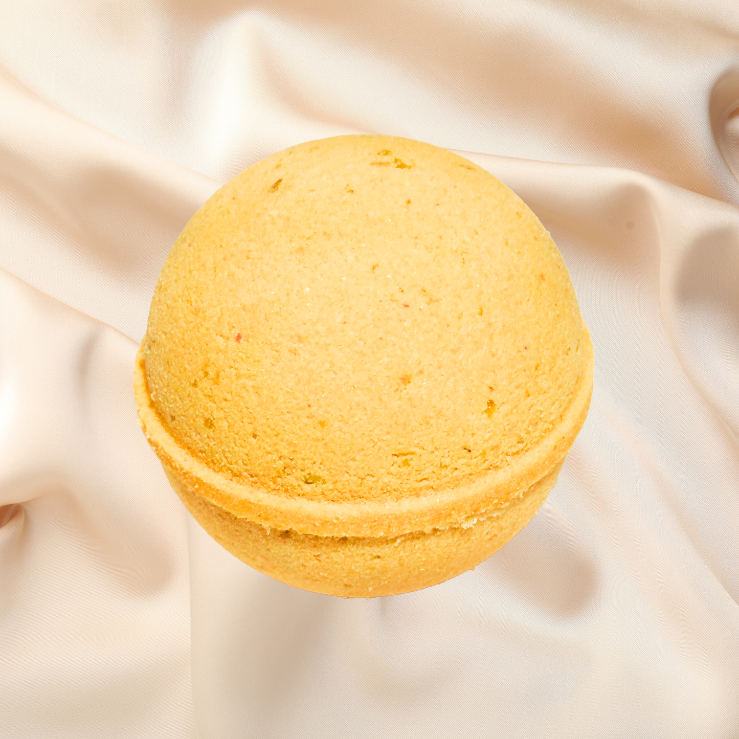 Yellow bath bomb on a beige fabric background
