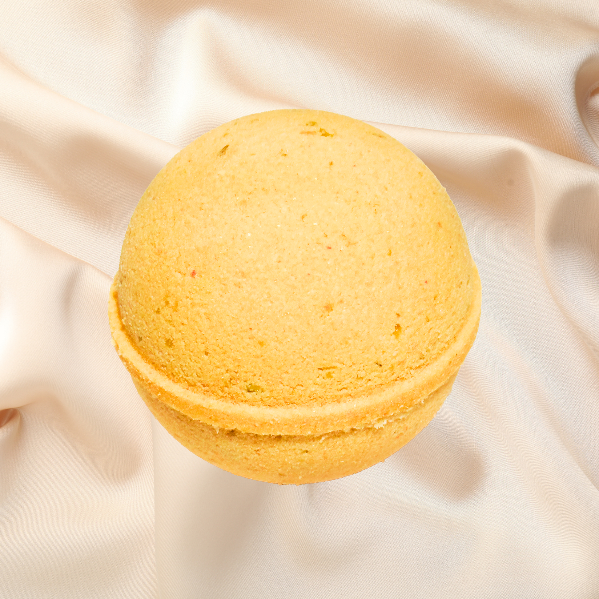 Yellow bath bomb on a beige fabric background